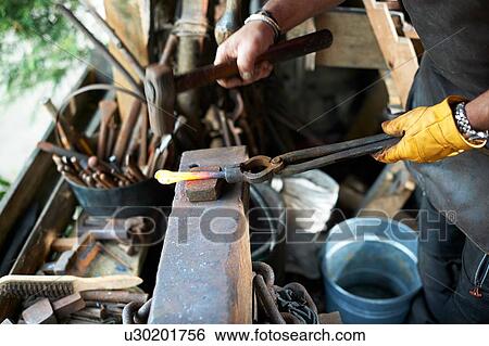 Stock Photograph - Blacksmith working in his forge. Fotosearch