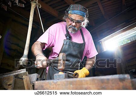 Blacksmith working in his forge View Large Photo Image Stock Photography - Blacksmith working in his forge. Fotosearch
