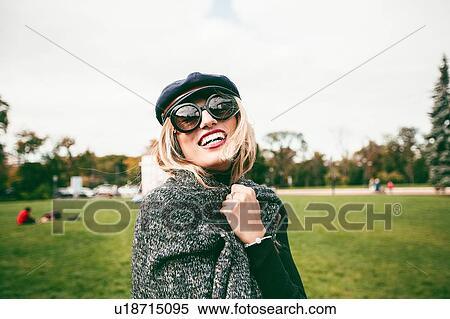 Blond woman wearing sunglasses in park, portrait View Large Photo Image Stock Photography - Blond woman wearing sunglasses in park, portrait. Fotosearch