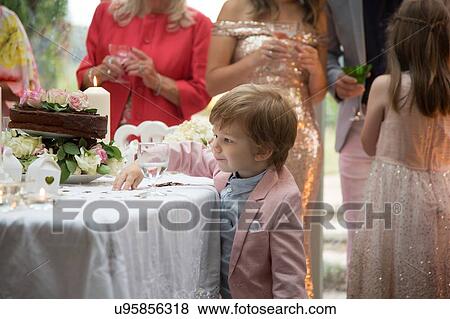 Boy curious about gifts and cake at wedding reception View Large Photo Image Stock Photo - Boy curious about gifts and cake at wedding reception. Fotosearch