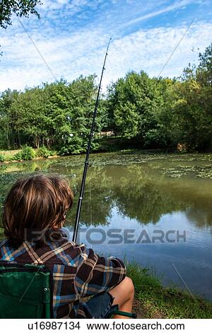 Boy fishing by lakeside, Bournemouth, UK View Large Photo Image Picture - Boy fishing by lakeside, Bournemouth, UK. Fotosearch
