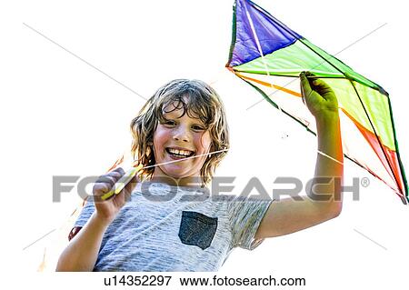 Boy holding kite in park, smiling. View Large Photo Image Stock Photo - Boy holding kite in park, smiling.. Fotosearch