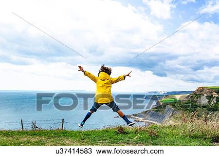 Boy jumping on clifftop by sea, Bournemouth, UK View Large Photo Image Stock Image - Boy jumping on clifftop by sea, Bournemouth, UK. Fotosearch