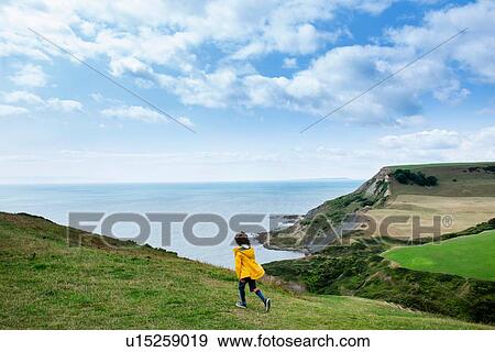 Boy on clifftop looking out to sea, Bournemouth, UK View Large Photo Image Stock Photo - Boy on clifftop looking out to sea, Bournemouth, UK. Fotosearch