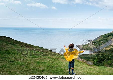 Stock Photography - Boy on clifftop looking out to sea, Bournemouth, UK. Fotosearch