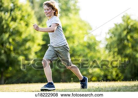 Boy running in park, smiling. View Large Photo Image Stock Photo - Boy running in park, smiling.. Fotosearch