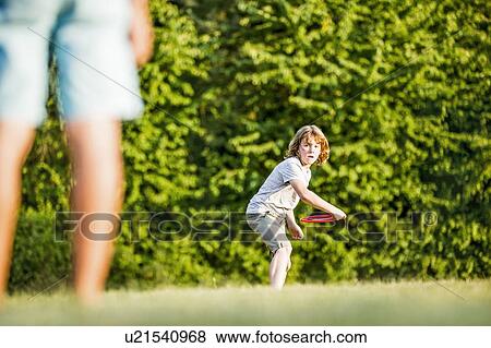 Boy throwing flying disc in park. View Large Photo Image Stock Photo - Boy throwing flying disc in park.. Fotosearch