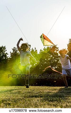 Boys holding kite and running in park. View Large Photo Image Stock Photo - Boys holding kite and running in park.. Fotosearch