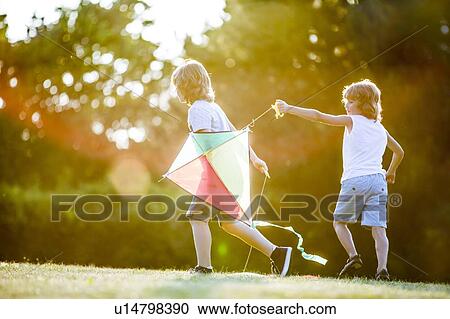 Boys playing with kite in park. View Large Photo Image Stock Image - Boys playing with kite in park.. Fotosearch