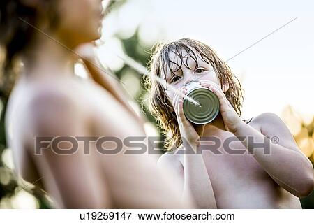 Stock Photo - Boys playing with tin can telephone.. Fotosearch