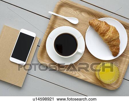 Stock Image - Breakfast tray and smartphone.. Fotosearch