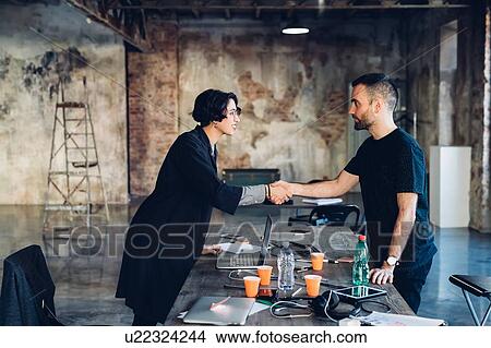 Business people shaking hands in studio View Large Photo Image Picture - Business people shaking hands in studio. Fotosearch