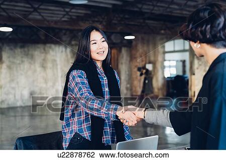 Business people shaking hands in studio View Large Photo Image Stock Image - Business people shaking hands in studio. Fotosearch