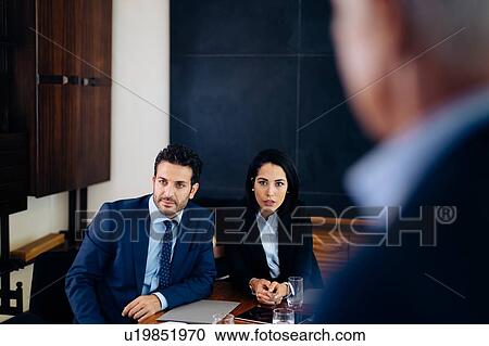 Businessman and woman watching presentation, over shoulder view View Large Photo Image Stock Image - Businessman and woman watching presentation, over shoulder view. Fotosearch
