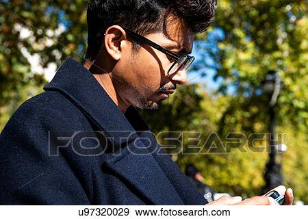 Businessman using smartphone outdoors View Large Photo Image Stock Photo - Businessman using smartphone outdoors. Fotosearch