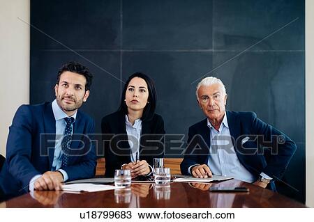 Businessmen and woman at boardroom table listening to presentation View Large Photo Image Stock Image - Businessmen and woman at boardroom table listening to presentation. Fotosearch