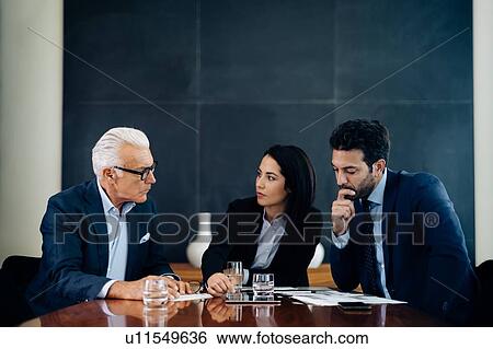 Businessmen and woman having discussion at boardroom table View Large Photo Image Stock Photograph - Businessmen and woman having discussion at boardroom table. Fotosearch