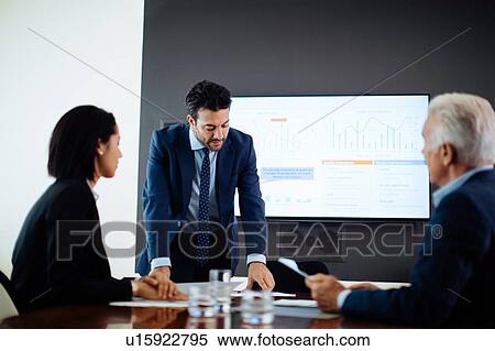 Businessmen and woman meeting at boardroom table View Large Photo Image Stock Photography - Businessmen and woman meeting at boardroom table. Fotosearch