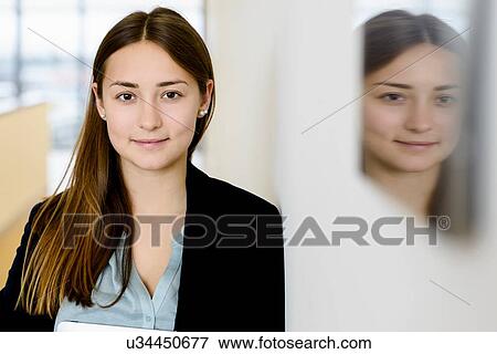 Stock Photo - Businesswoman and her mirror reflection on wall. Fotosearch