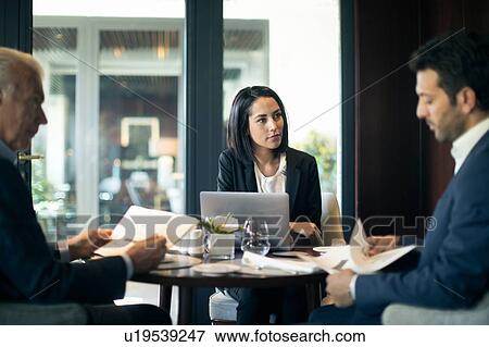 Businesswoman and men having meeting in hotel restaurant View Large Photo Image Stock Photo - Businesswoman and men having meeting in hotel restaurant. Fotosearch