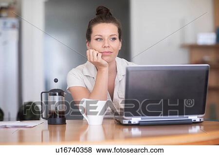 Businesswoman thinking in front of laptop View Large Photo Image Stock Photo - Businesswoman thinking in front of laptop. Fotosearch
