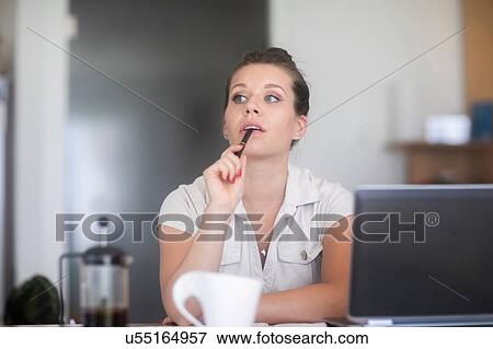 Businesswoman thinking in front of laptop View Large Photo Image Stock Photo - Businesswoman thinking in front of laptop. Fotosearch