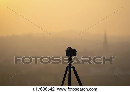 Stock Image - Camera on tripod overlooking village.. Fotosearch