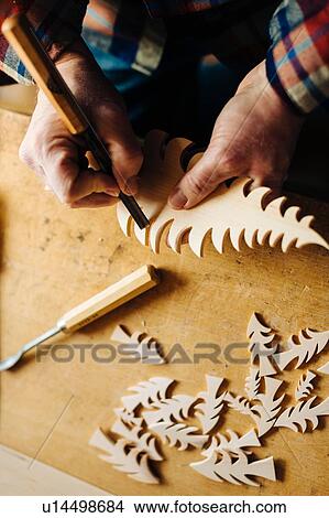 Carpenter chiseling edge of wooden christmas tree at workbench, overhead close up of hands View Large Photo Image Picture - Carpenter chiseling edge of wooden christmas tree at workbench, overhead close up of hands. Fotosearch