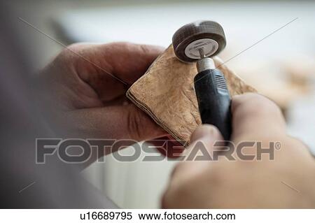 Stock Photography - Carpenter sanding wood square with sanding tool. Fotosearch