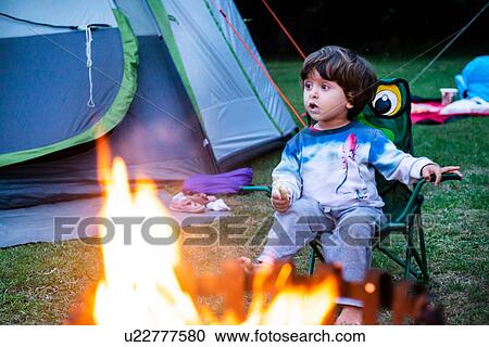 Child relaxing in front of bonfire View Large Photo Image Stock Image - Child relaxing in front of bonfire. Fotosearch