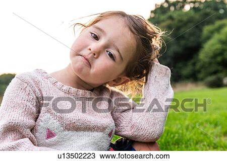 Child sitting on grass in park View Large Photo Image Stock Image - Child sitting on grass in park. Fotosearch