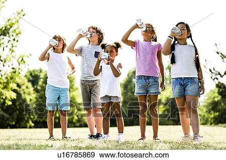 Stock Photo - Children drinking water in park.. Fotosearch