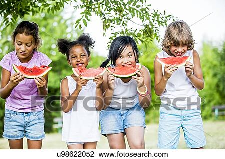 Children eating watermelon in park. View Large Photo Image Stock Image - Children eating watermelon in park.. Fotosearch