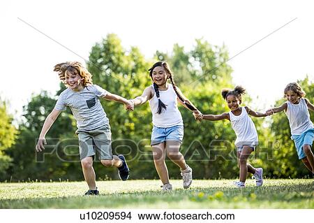 Children holding hands and running in park, laughing. View Large Photo Image Picture - Children holding hands and running in park, laughing.. Fotosearch