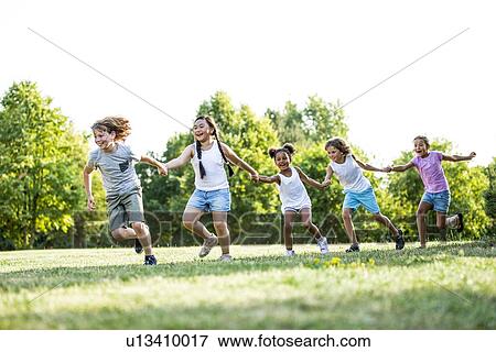 Children holding hands and running in park, laughing. View Large Photo Image Stock Photo - Children holding hands and running in park, laughing.. Fotosearch