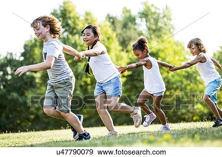 Children holding hands and running in park, smiling. View Large Photo Image Stock Photo - Children holding hands and running in park, smiling.. Fotosearch