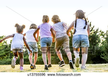 Children holding hands and running in park. View Large Photo Image Stock Photograph - Children holding hands and running in park.. Fotosearch
