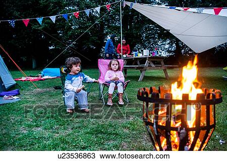 Children relaxing in front of bonfire, parents in background View Large Photo Image Stock Image - Children relaxing in front of bonfire, parents in background. Fotosearch