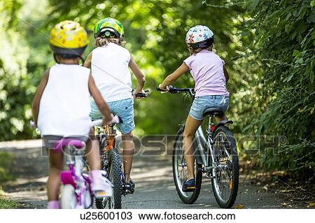 Children wearing helmets and cycling in park. View Large Photo Image Stock Image - Children wearing helmets and cycling in park.. Fotosearch