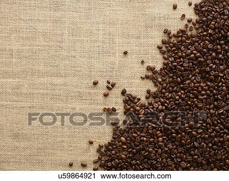 Stock Image - Coffee beans against a brown background.. Fotosearch