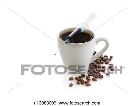 Stock Photo - Coffee cup with beans and a syringe, conceptual studio shot.. Fotosearch