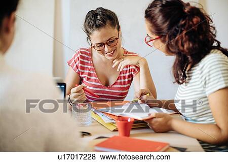 Colleagues discussing documents View Large Photo Image Stock Photo - Colleagues discussing documents. Fotosearch