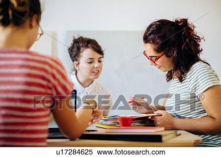 Stock Photography - Colleagues discussing documents. Fotosearch