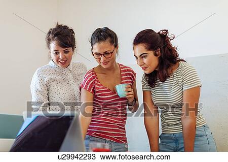 Colleagues using laptop together View Large Photo Image Stock Image - Colleagues using laptop together. Fotosearch