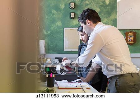 Stock Image - Colleagues working in office. Fotosearch