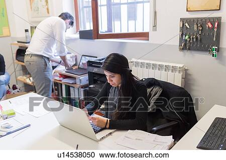 Colleagues working in office View Large Photo Image Stock Image - Colleagues working in office. Fotosearch