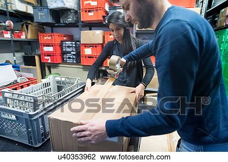 Colleagues working on delivery and packaging in warehouse View Large Photo Image Stock Image - Colleagues working on delivery and packaging in warehouse. Fotosearch