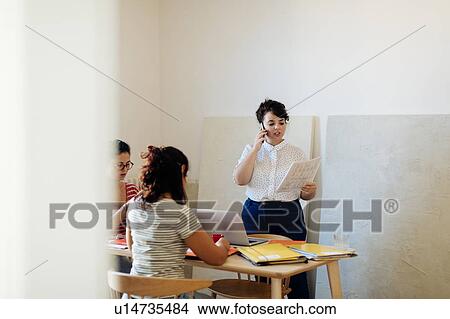 Picture - Colleagues working on project around table. Fotosearch