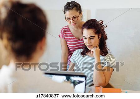 Colleagues working on project around table View Large Photo Image Stock Photo - Colleagues working on project around table. Fotosearch