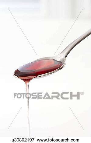 Stock Photo - Cough syrup dripping from a spoon.. Fotosearch